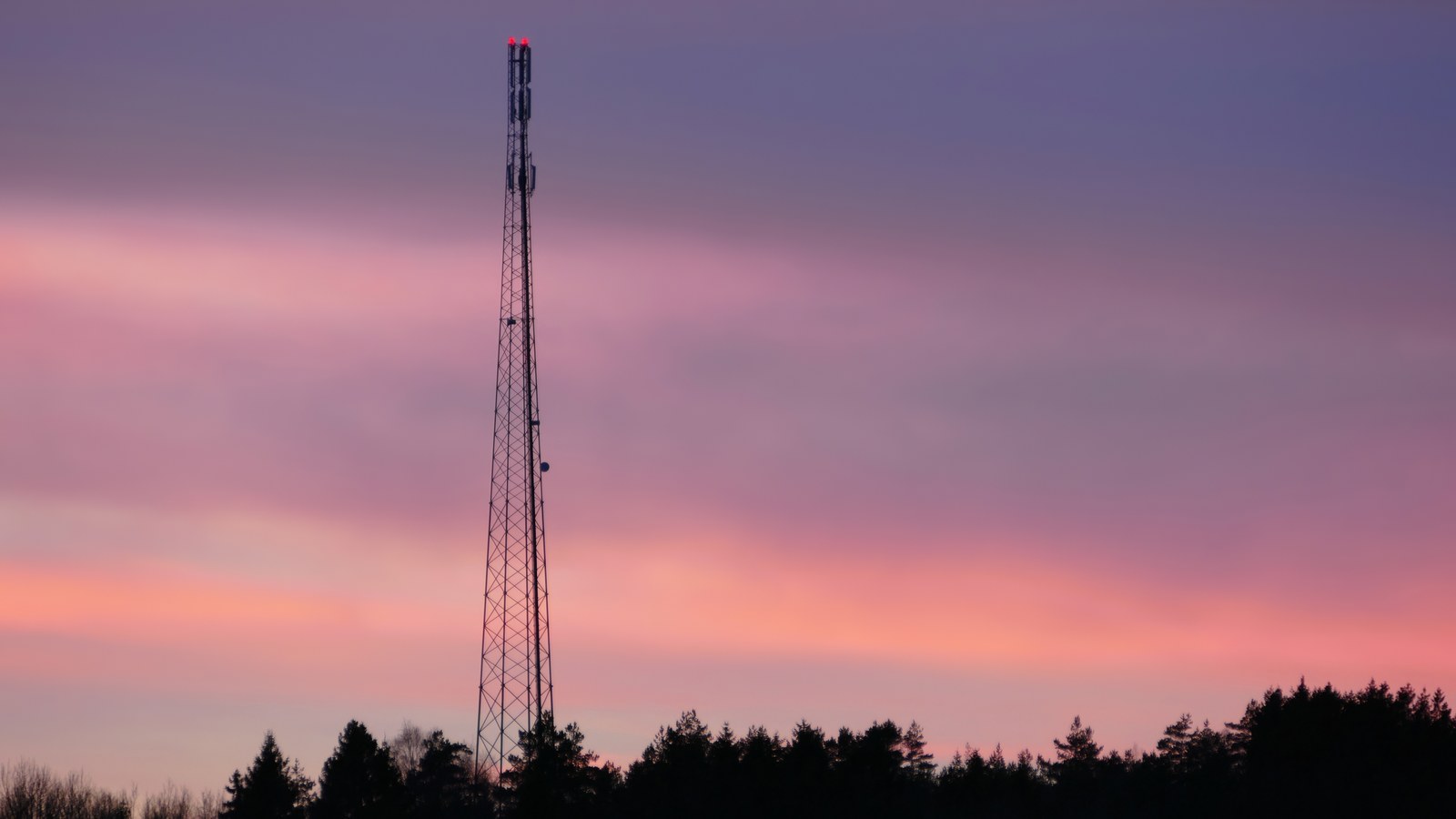 High-altitude telecommunications cellular mast and Massive MIMO antenna array against dusk sky demonstrating modern Open RAN macro cell infrastructure
